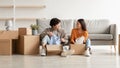 Cheerful Asian couple unpacking belongings and having conversation, moving to new apartment or their own house Royalty Free Stock Photo