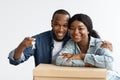 Relocation. Portrait Of Happy Black Spouses Posing With Keys And Cardboard Box