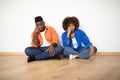 Relocation Problems. Upset Bored Black Couple Sitting On Floor In New Apartment