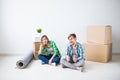 Relocation, real estate and moving concept - young couple people moved to a new apartment