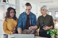 They rely on teamwork to get the job done. three creative businesspeople working together on a laptop in their office. Royalty Free Stock Photo