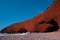 Remaining red sandstone stone arch in Legzira Beach. Rugged coastline in Tiznit Province of Morocco, Africa. Atlantic Ocean waves. Royalty Free Stock Photo