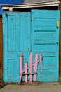 Broken pick fence leans against an old set of double doors.