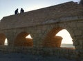 Keysaria. Israel. 2 people sitting on Roman aqueduct .caesarea.