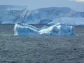 Eroded blue iceberg floats in the Lemaire Channel Antarctica