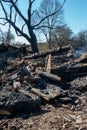 The remains of a burnt-out old wooden house in the village. A burned house and injured people as a result of a forest fire. Royalty Free Stock Photo