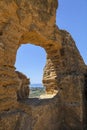 The remains of the city walls of the ancient Greek Akragas as a window on the panorama. The sea as background. Agrigento, Sicily,