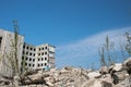 The remains of a destroyed building against a textured blue sky