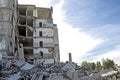 The remains of the destroyed concrete building against the textured blue sky. Space for text. Background