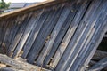 The remains of an old, destroyed roof lie on the ground after the demolition of the barn. Day.