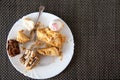 The remains of pastries and cake in a plate on the table. Harmful delicious sweet food. Close-up, copy space for text