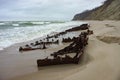 The remains of a ship on the sand, pieces of rusty iron on the seashore