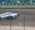 Remains of small cars in the dealership parking and jobless rack-car trucks nearby Royalty Free Stock Photo