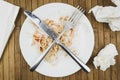 Remains of spaghetti, fork and knife on a white plate.