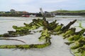 Remains of wooden wreck on sand beach