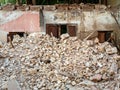 The remains of the demolished building are a pile of bricks and a wall with a door Royalty Free Stock Photo