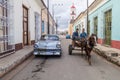 REMEDIOS, CUBA - FEB 12, 2016: Horse carriage and a vintage Chevrolet car in Remedios town, Cu