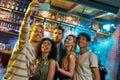 Remember the night. Young men and women smiling while taking selfie using smartphone. Multiracial group of friends Royalty Free Stock Photo