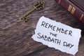 Remember Sabbath Day, handwritten Christian text note with holy bible and antique key on wooden table