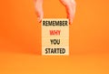 Remember why you started symbol. Concept word Remember why you started on wooden block. Beautiful orange table background.