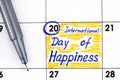 Reminder International Day of Happiness in calendar with pen