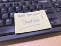 A Reminder Label Note to Meet a Deadline Placed on Top of a Black Computer Keyboard. Royalty Free Stock Photo