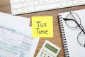 Reminder note with words Tax Time, documents, computer keyboard and calculator on wooden table, flat lay Royalty Free Stock Photo