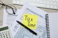 Reminder note with words Tax Time, documents, computer keyboard, glasses and calculator on white wooden table, flat lay Royalty Free Stock Photo