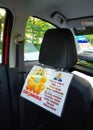 A reminder plate to put on a mask in the taxi car. Coronavirus pandemic