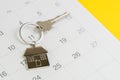 Reminder to pay for mortgage, schedule event or real estate payment day, silver house keyring on white clean calendar, yellow Royalty Free Stock Photo