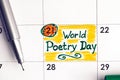 Reminder World Poetry Day in calendar with green pen. 21 March