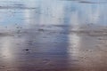 Remnant of water on the sand on the beach with some footsteps Royalty Free Stock Photo