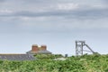 Remnants of Botallack Crown tin mining structure and roof of Cornish cottage poking abve hedgerows.West Penwith,Cornwall,England, Royalty Free Stock Photo