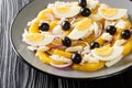 Remojon Andaluz contains fresh oranges, onion, boiled eggs, black olives and delicious salt cod close-up in a plate. Horizontal