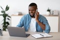 Remote Business. Black Male Freelancer Worjing With Cellphone And Laptop At Home Royalty Free Stock Photo
