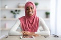 Remote Career. Black Female In Hijab Sitting At Desk With Digital Tablet