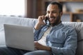 Remote Career. Happy Smiling Black Man Talking On Phone And Using Laptop Royalty Free Stock Photo
