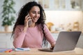 Remote Career. Young Happy Female Freelancer Using Cellphone And Laptop In Kitchen