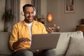 Young black man in headphones using laptop for online chat, having video conference or business meeting at home Royalty Free Stock Photo