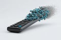 Remote device dissolving into streams of binary code and digital data particles Royalty Free Stock Photo