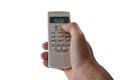 Hand holding the air conditioner remote control and thumb is pressing a button on the remote,  on a white background. Royalty Free Stock Photo