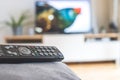 Remote control on the sofa, streaming on a smart TV Royalty Free Stock Photo