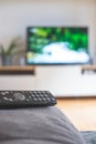 Remote control on the sofa, streaming on a smart TV Royalty Free Stock Photo