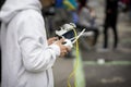 Remote controller, headset with smartphone in hands of teenager, young man close-up, piloting flying drone. Modern toy