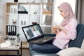 Remote doctor consultation online. Young sick Muslim woman in hijab takes an online consultation advice, talking with