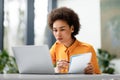 Remote education. Focused latin lady watching video course on laptop and taking notes, learning virtual lesson