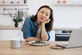 Remote employee sitting at table with laptop and salad Royalty Free Stock Photo