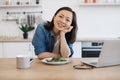 Remote employee sitting at table with laptop and salad Royalty Free Stock Photo