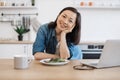 Remote employee sitting at table with laptop and salad Royalty Free Stock Photo