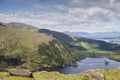 A remote and empty country side Irish road in county Kerry, with green fields, a lake, and distant mountains